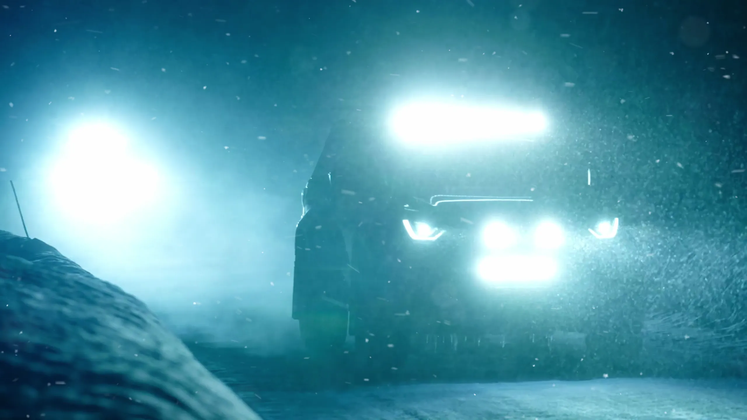 Bilen i tett snøvær med LED-rampen tent, ved en snøfonn i veikanten.