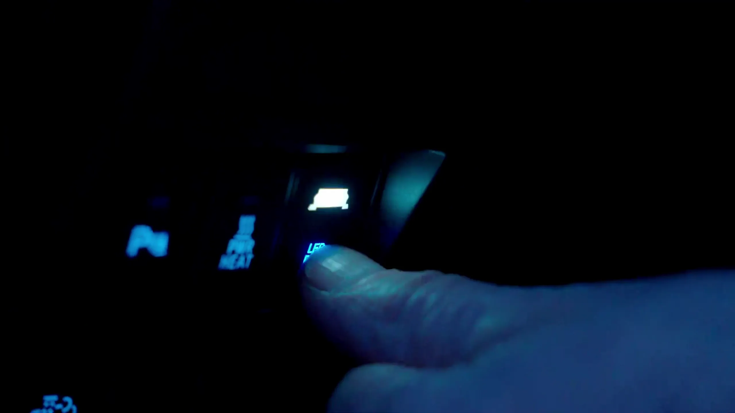 En finger trykker på bryteren for LED-rampen inne i kupeen.