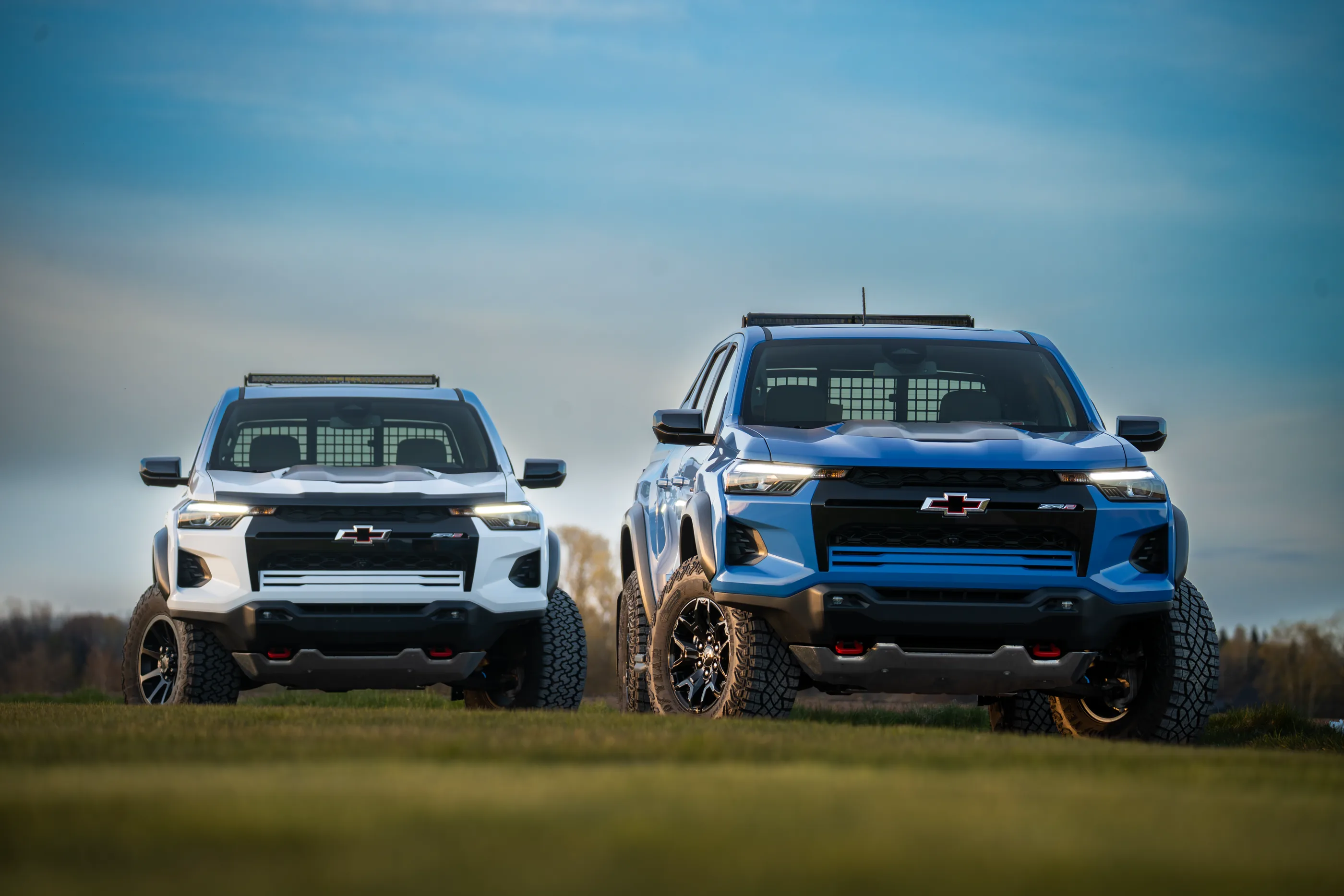 To Chevrolet Colorado ZR2, én hvit og én blå, side om side sett forfra.