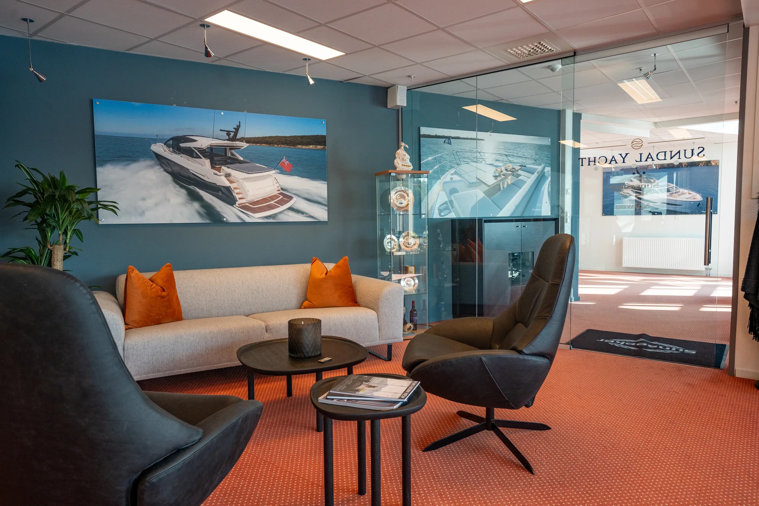 Loungeområdet hos Sundal Yacht med glassvegg og Sundal Yacht-logo.