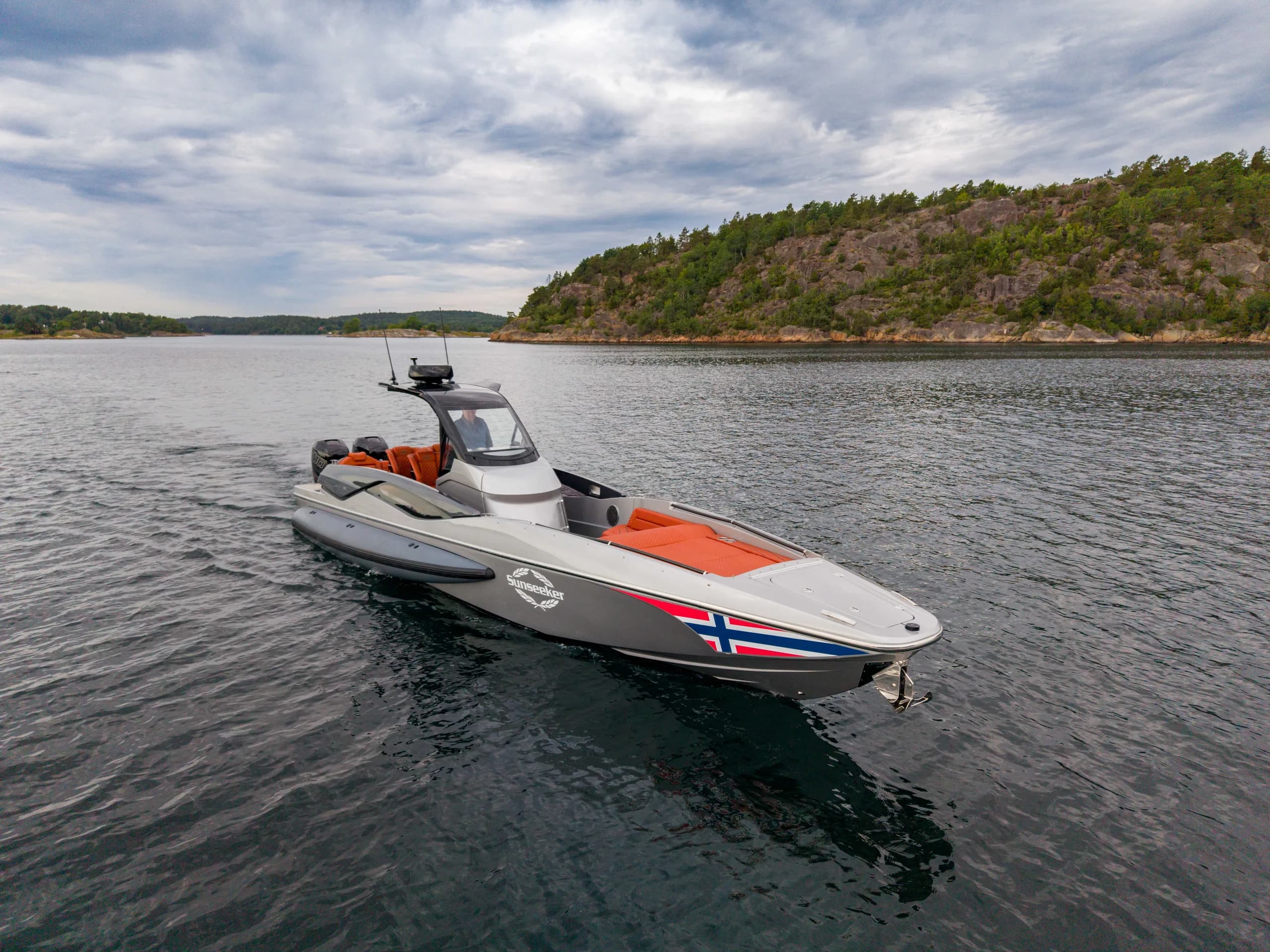 Sunseeker Hawk 38 med norsk flagg i fart langs kysten.