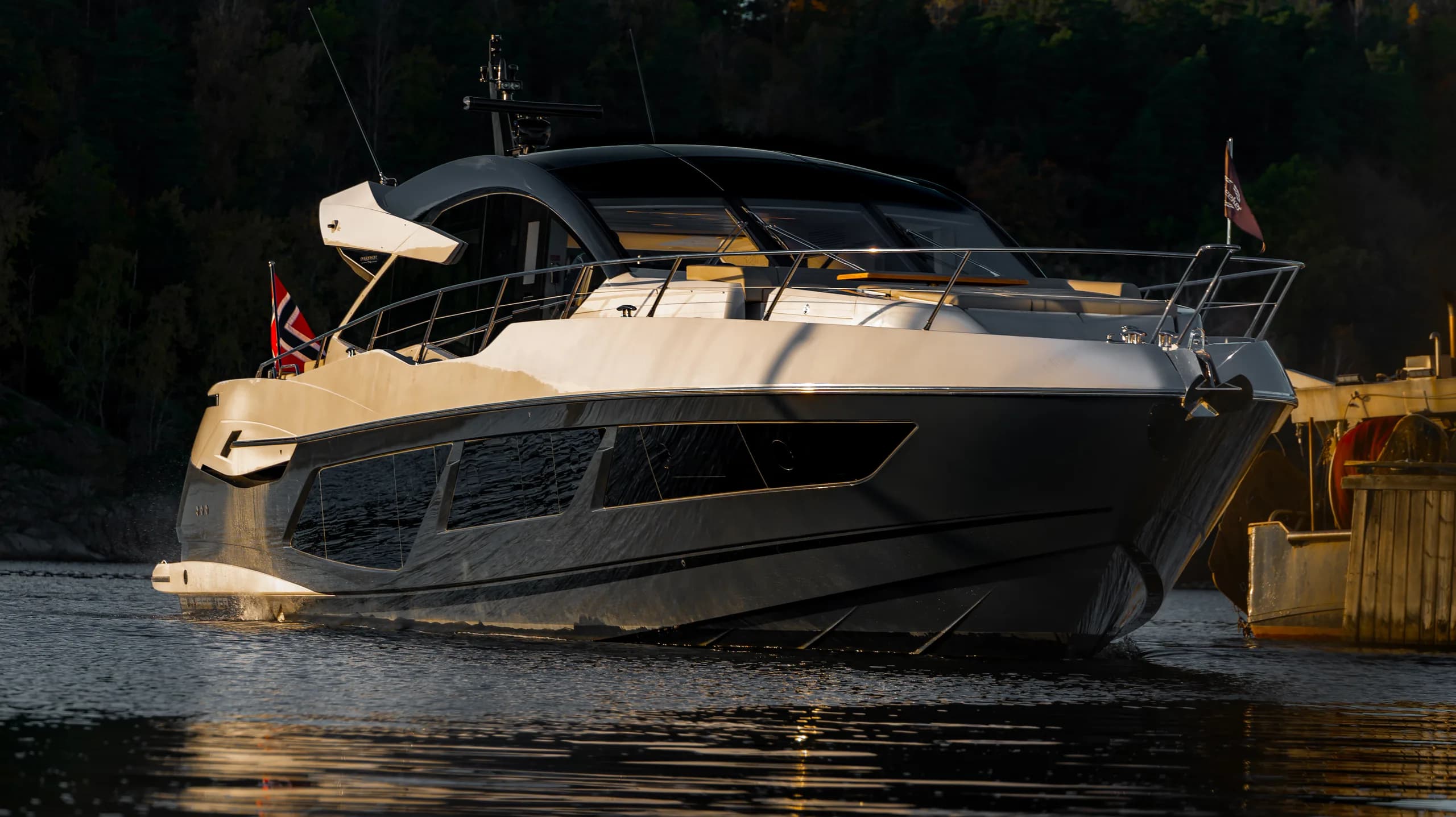 Sunseeker Predator 57 fortøyd i motlys ved kveldstid.